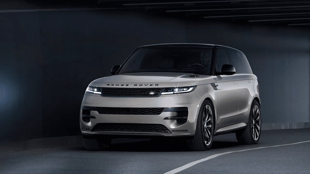 2026 Land Rover Range Rover Sport front three-quarter view driving out of a dark underground garage