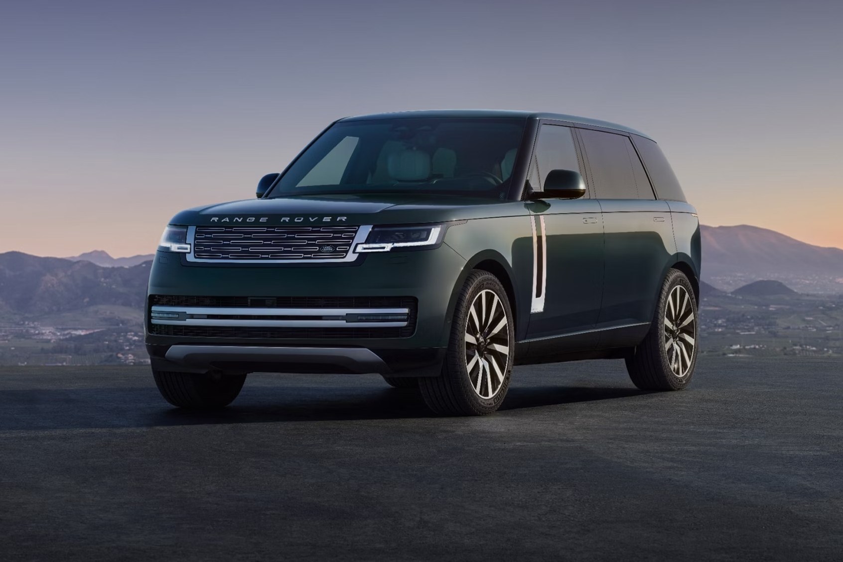 2027 Land Rover Range Rover front three-quarter view parked on a mountain overlook at dusk