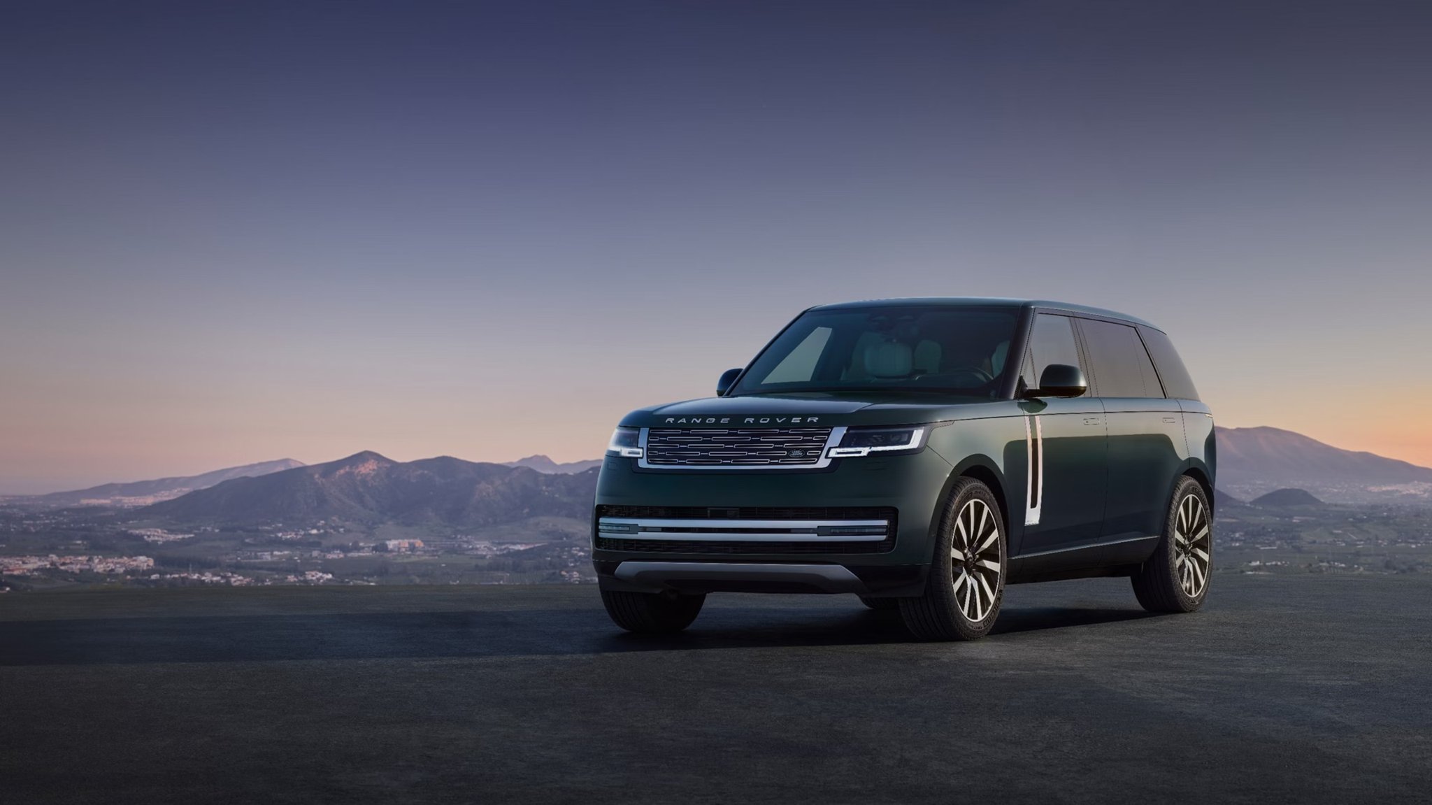 2027 Land Rover Range Rover front three-quarter view parked on a hilltop at dusk